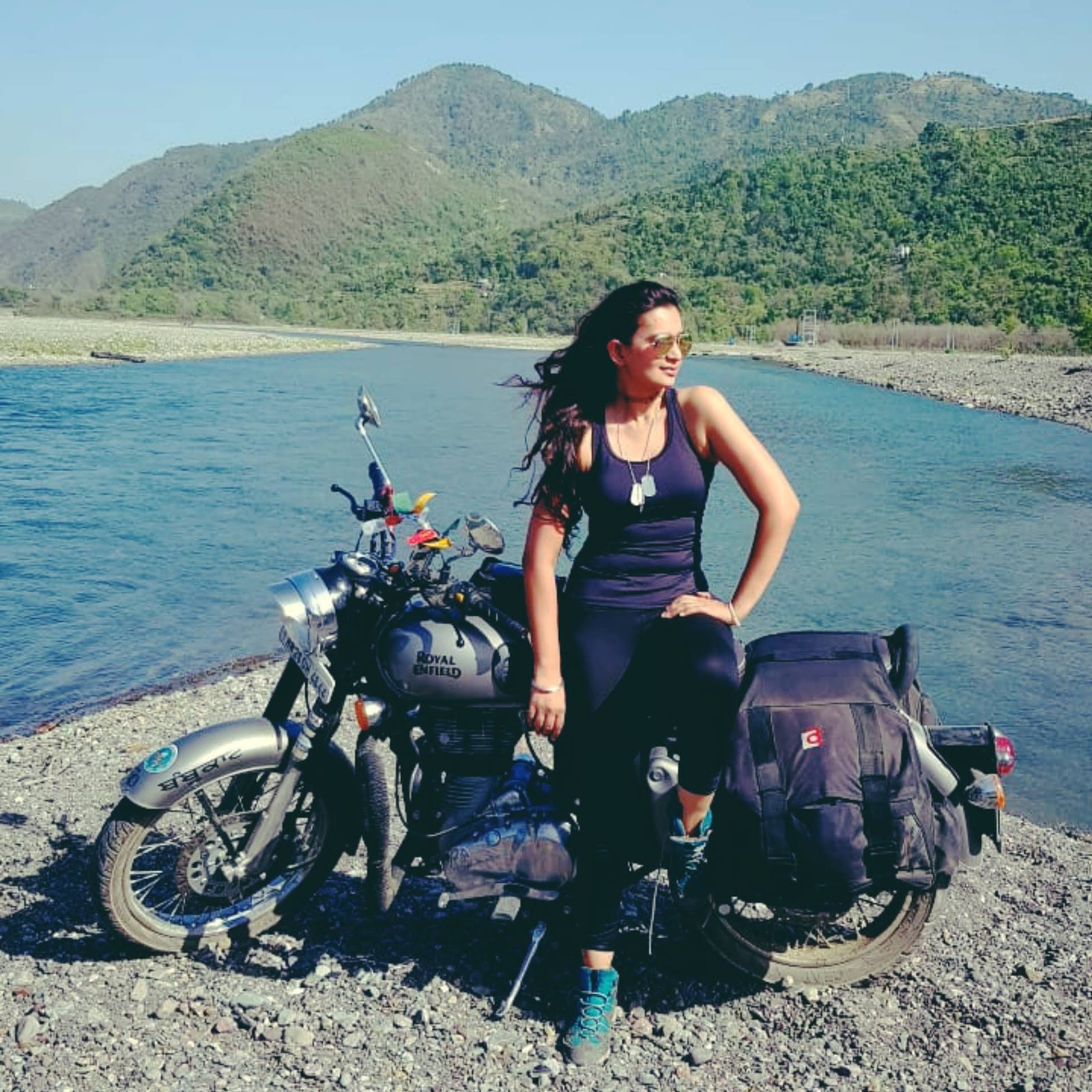 Divya and her motorcycle beside the water in 2019